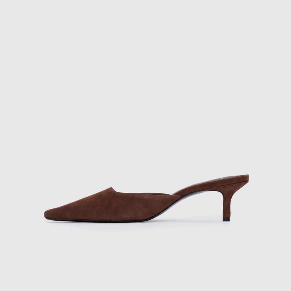 Brown suede slip-on shoe with a kitten heel on a light gray background