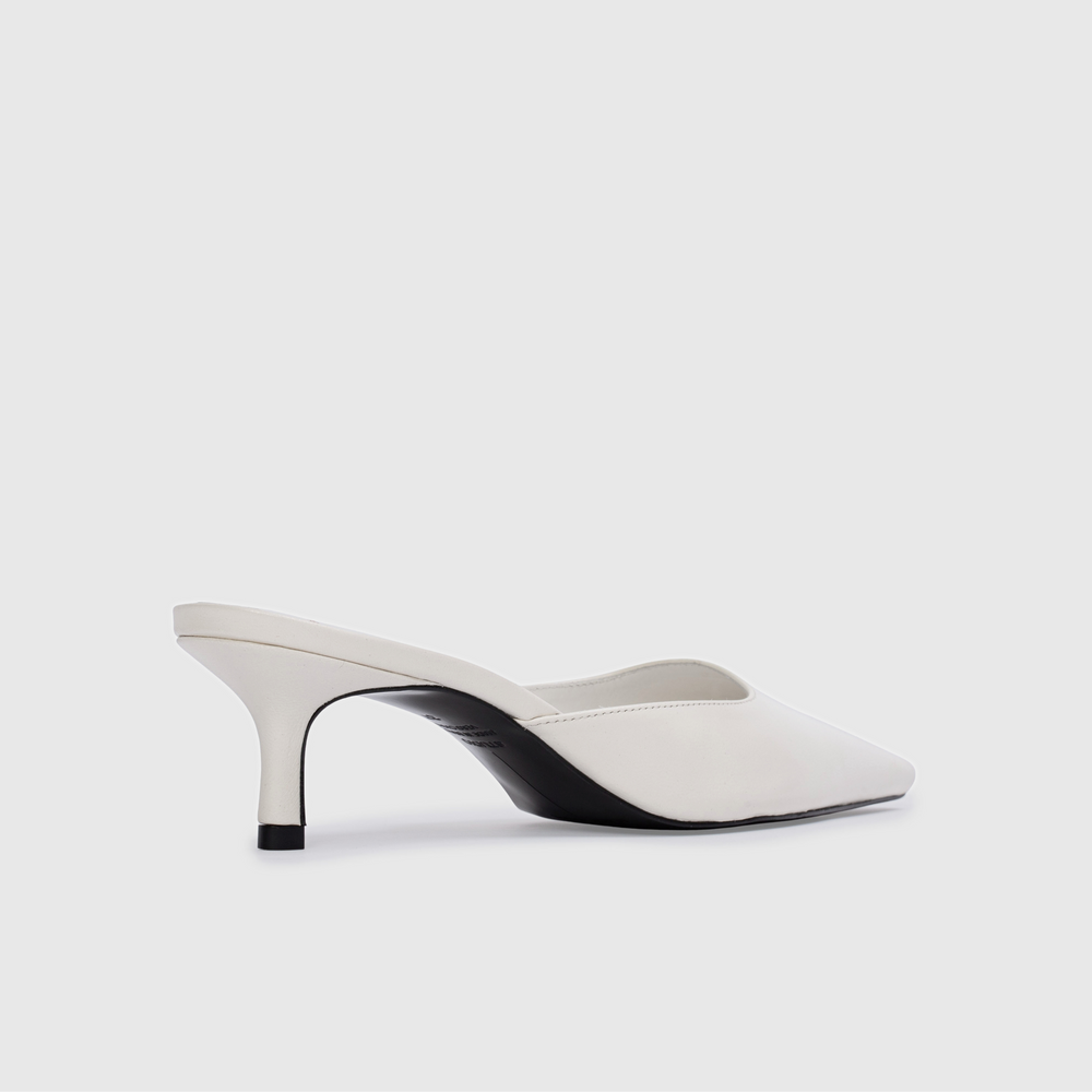 White high-heeled shoes with black accents on a light gray background