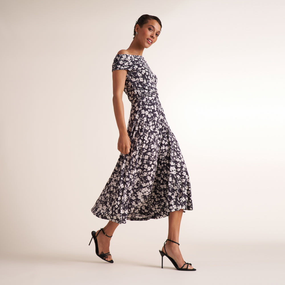 Woman wearing a matching shirt and long skirt in a black and white matching floral print