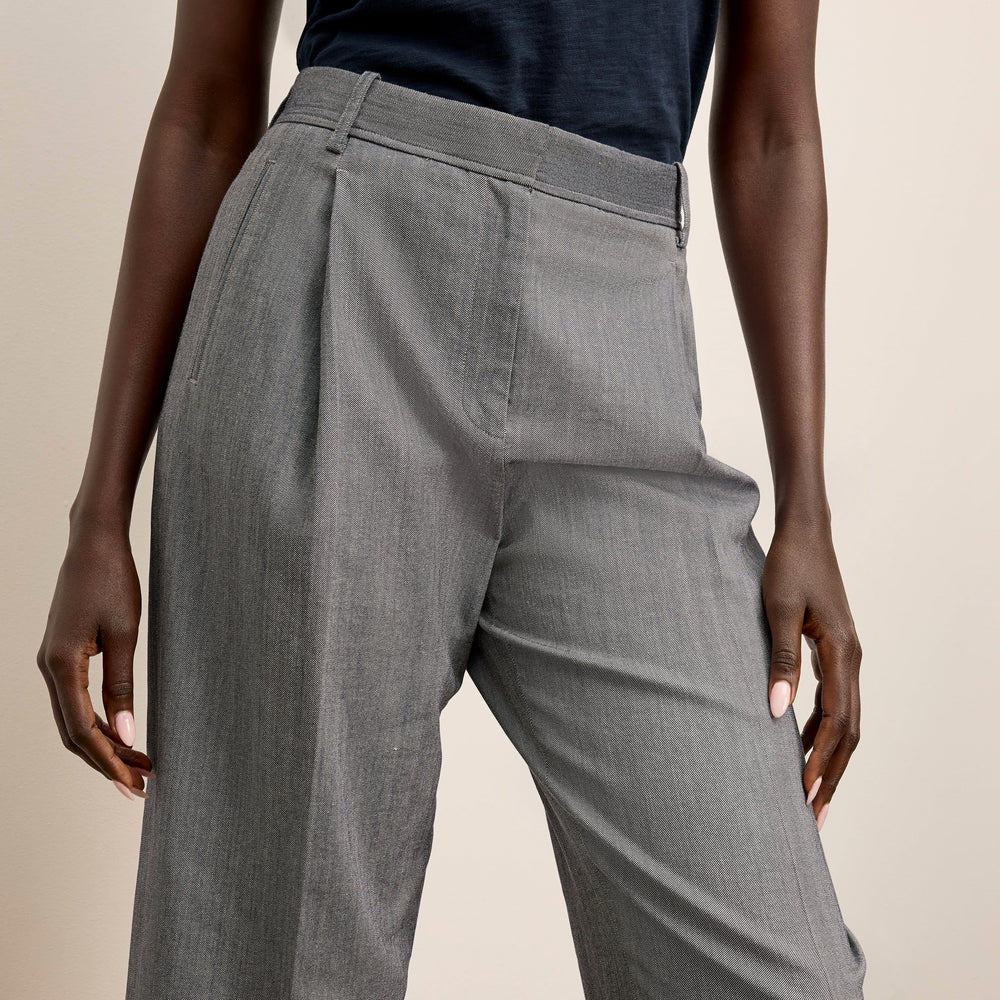 Gray pants worn by a person on a beige background