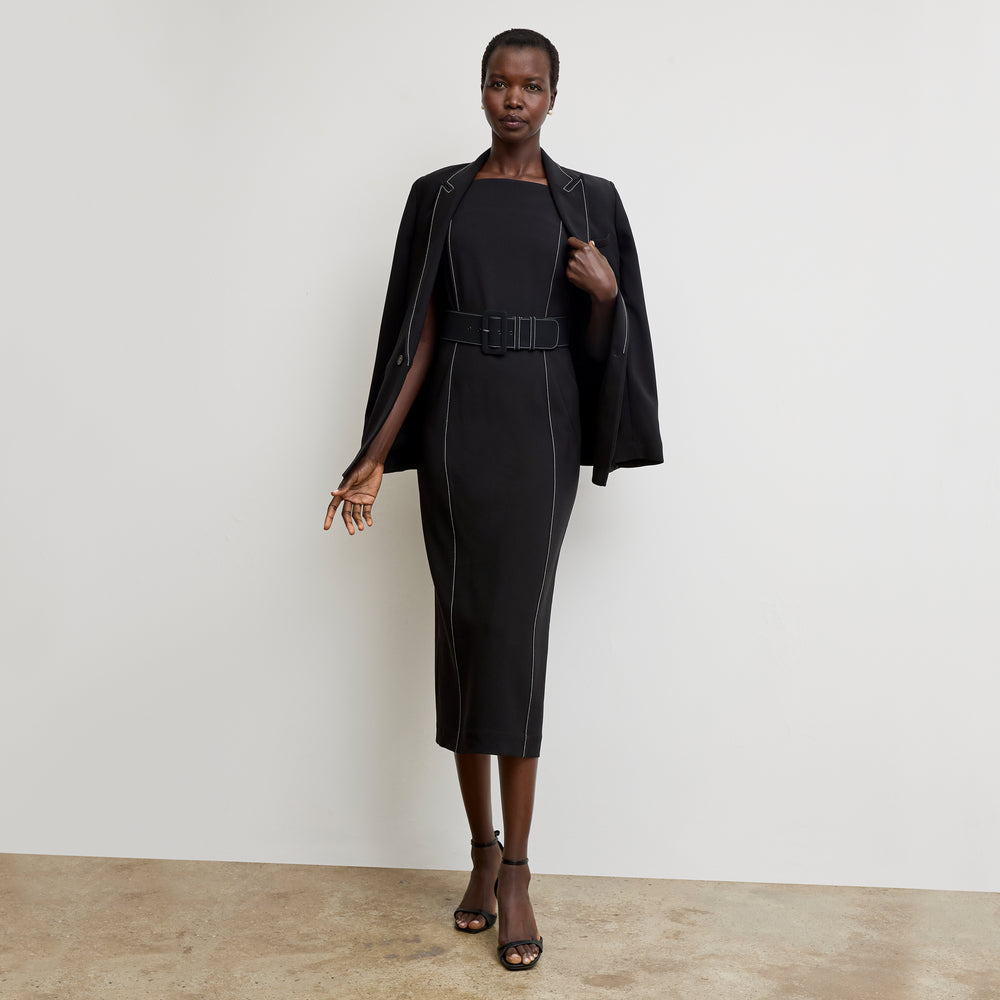 front image of a woman wearing the carmela dress in black with topstitch