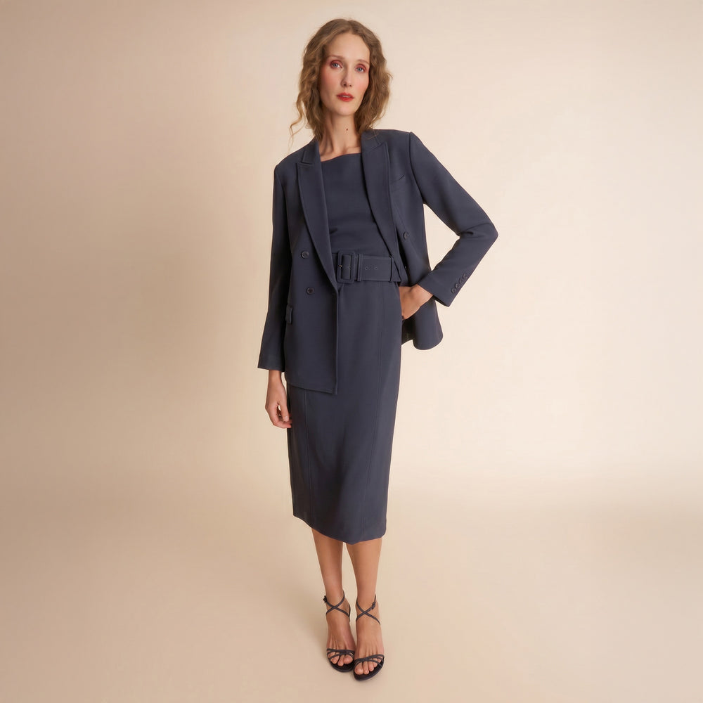 Woman wearing a navy blue suit on a beige background