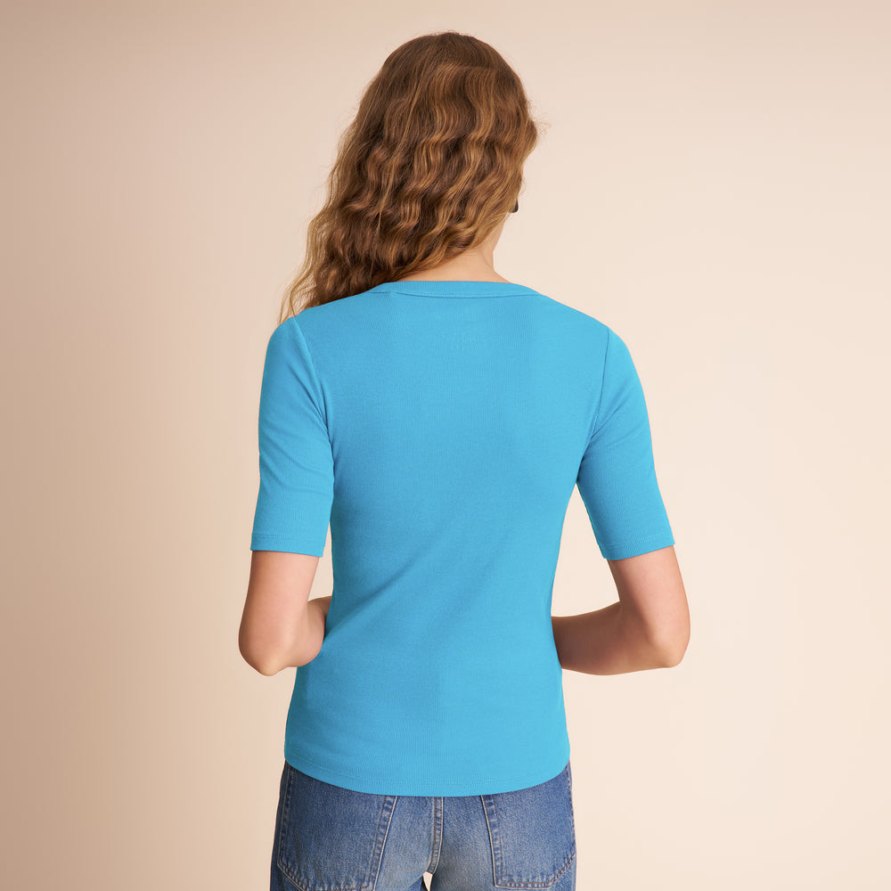 Person wearing a blue t-shirt and jeans on a beige background