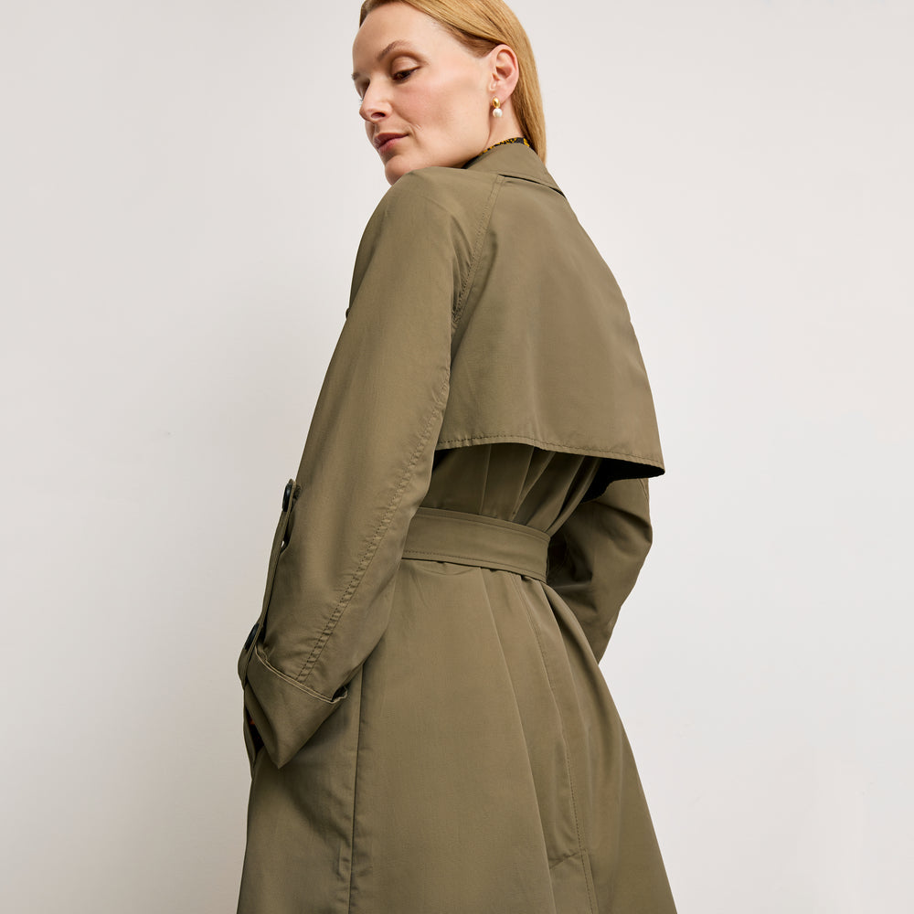 back image of a woman wearing the curtis trench in bancha green