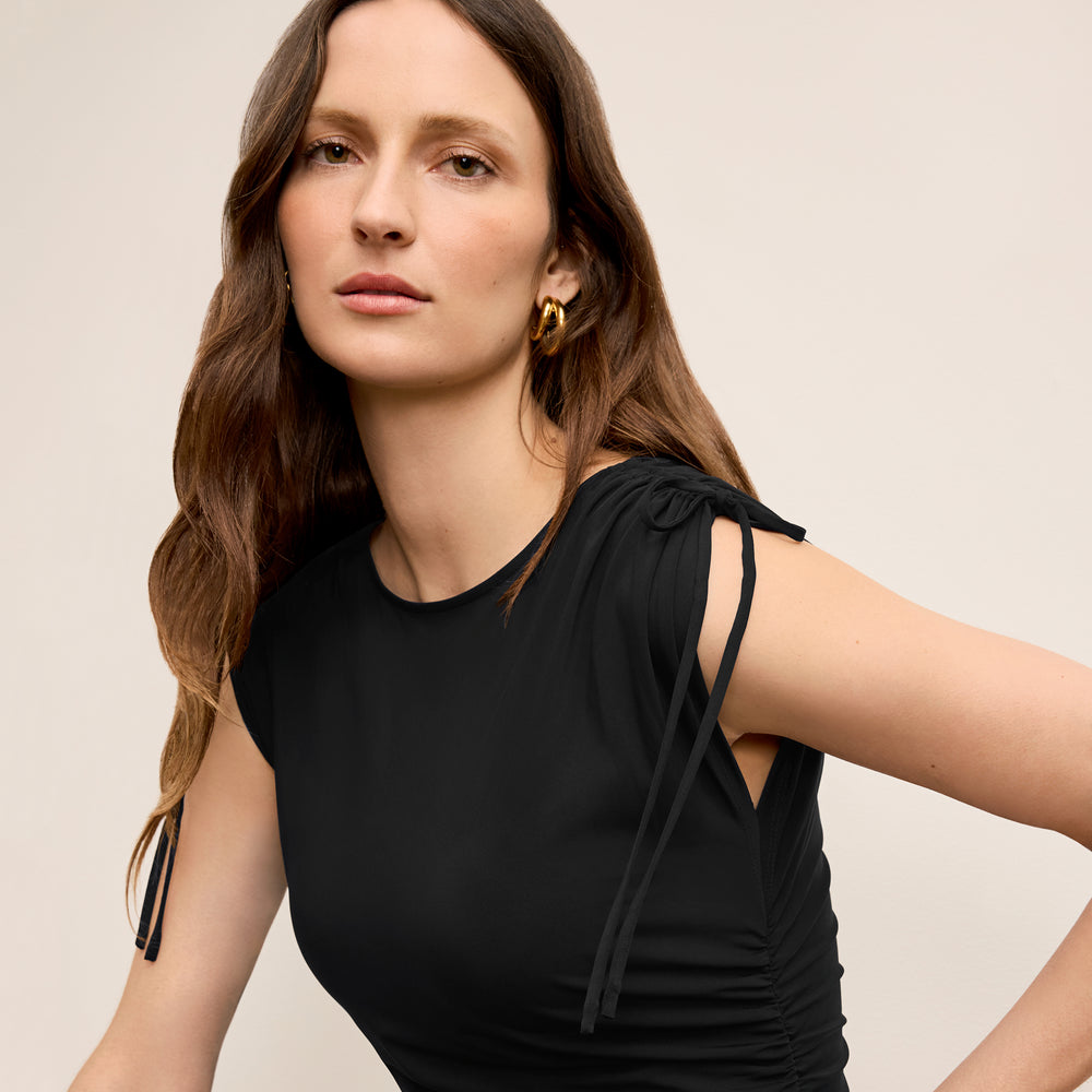 Front image of a woman wearing the Dotty Top in Black with denim jeans