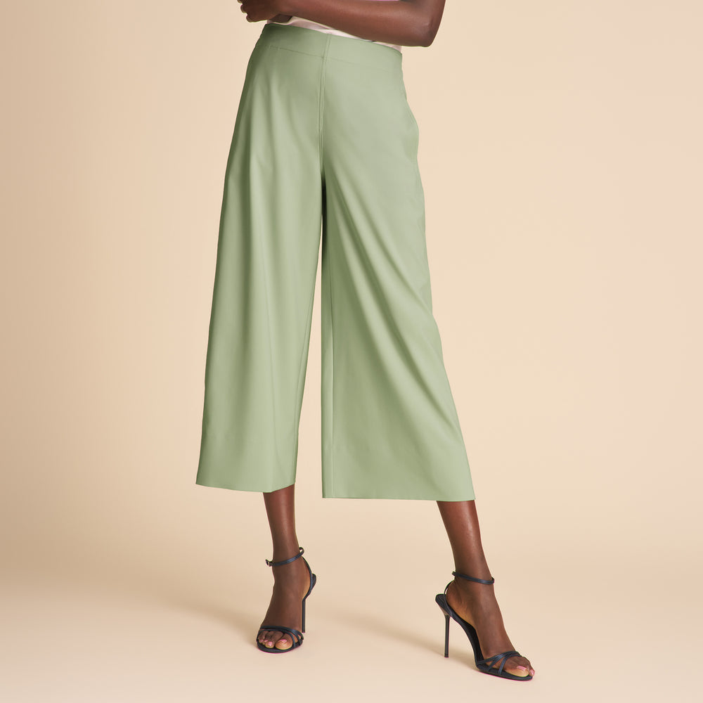 Person wearing light green wide-leg pants on a beige background