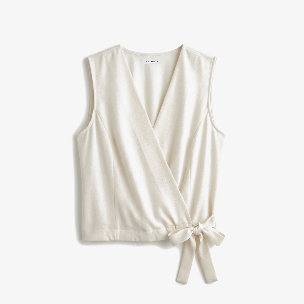 White sleeveless top with a tie detail on a white background