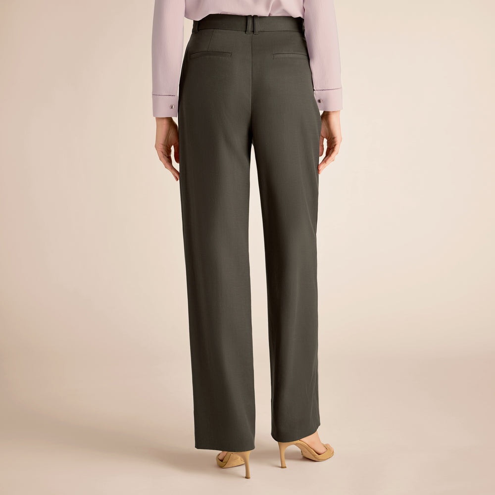 Dark gray pants worn by a person on a beige background