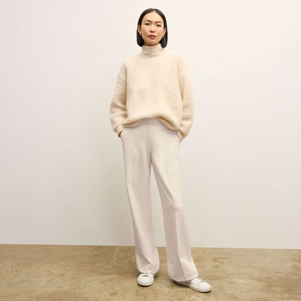 front image of a woman wearing the lea sweater in snow