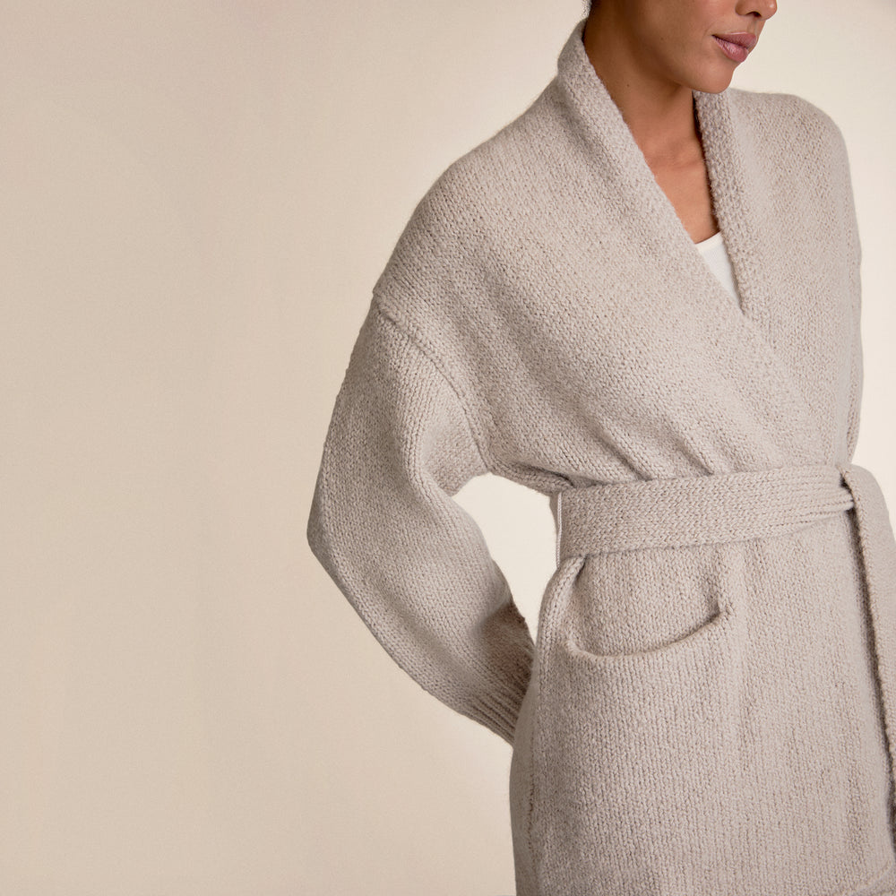 Beige robe worn by a person on a beige background