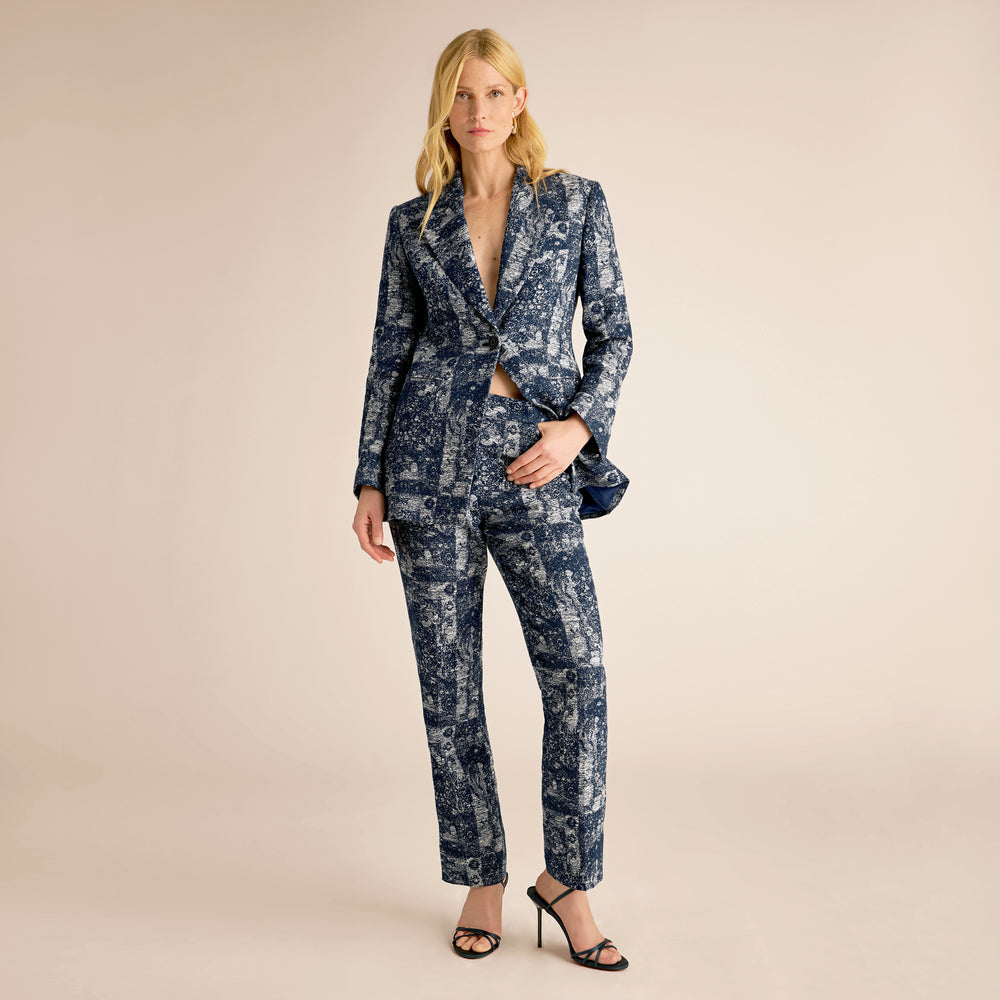 Woman wearing a blue patterned suit on a beige background