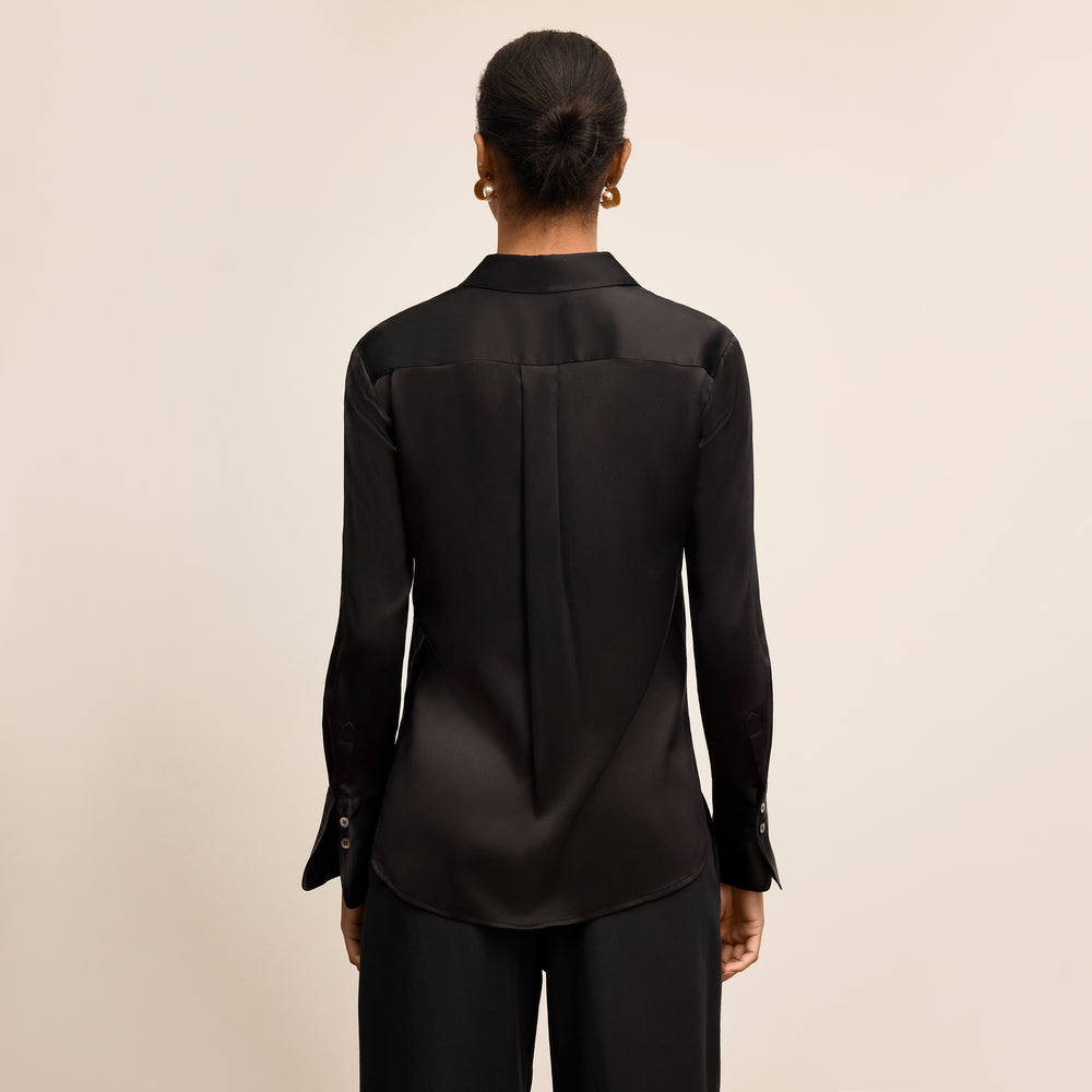 Person wearing a black shirt and pants on a beige background