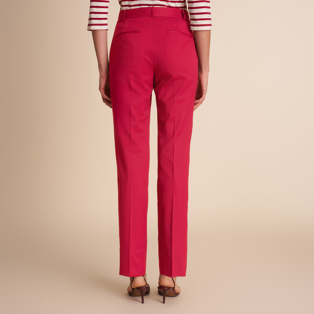 Red pants worn by a person on a beige background