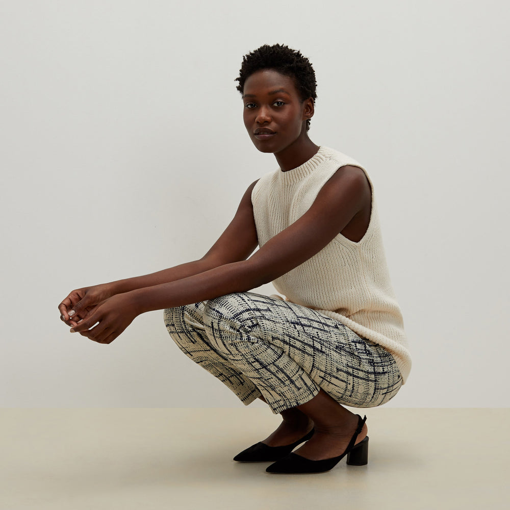 Side image of a woman standing wearing the Spardel top in ivory