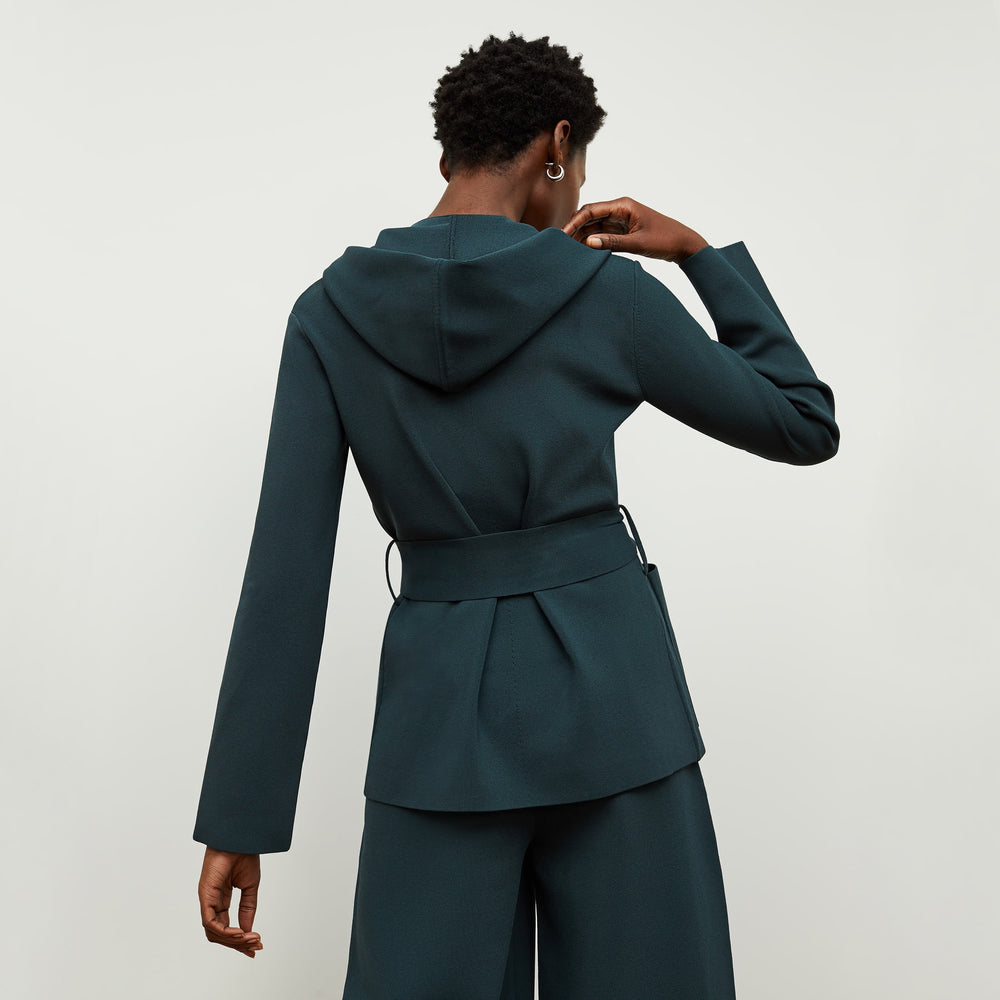 Back image of a woman standing wearing the colette jardigan in deep sea