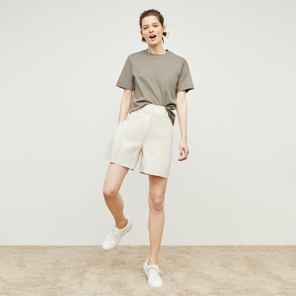Front image of a woman standing wearing the Leslie T-Shirt—Compact Cotton in Pebble