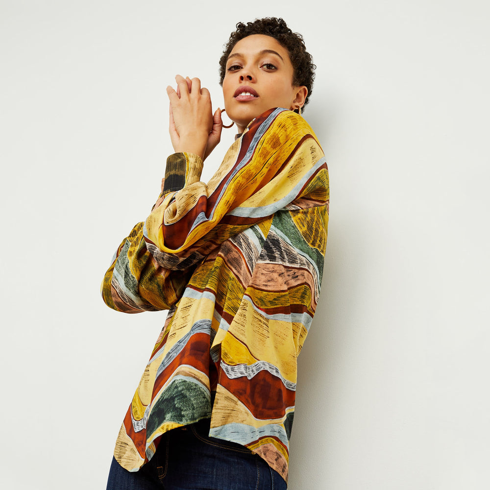 Side image of a woman standing wearing the Fiona TopāSilk Desert in Multicolor