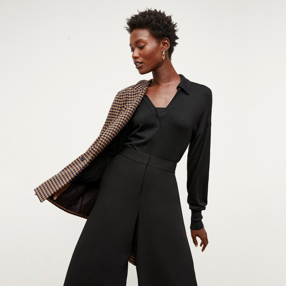 Front image of a woman standing wearing the leo top in silk jersey in black