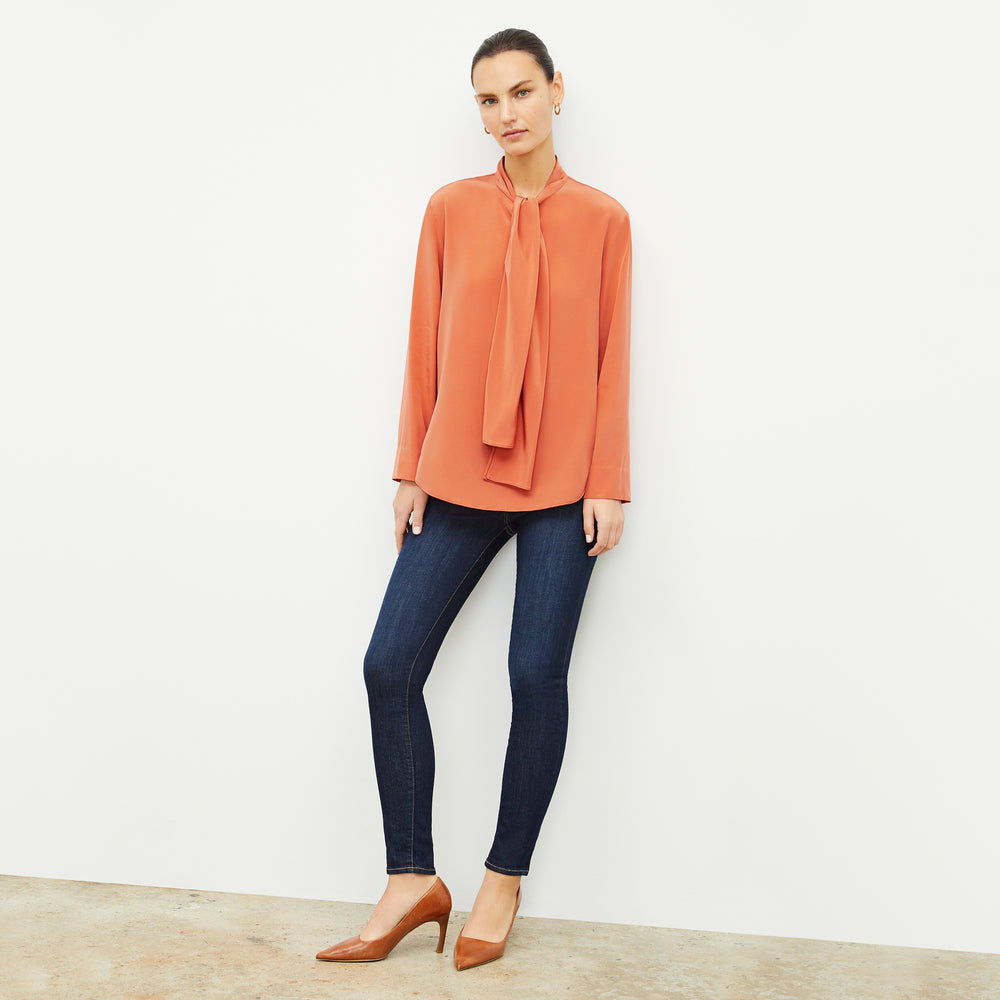 Front image of a woman wearing the Darcy Top in Guava