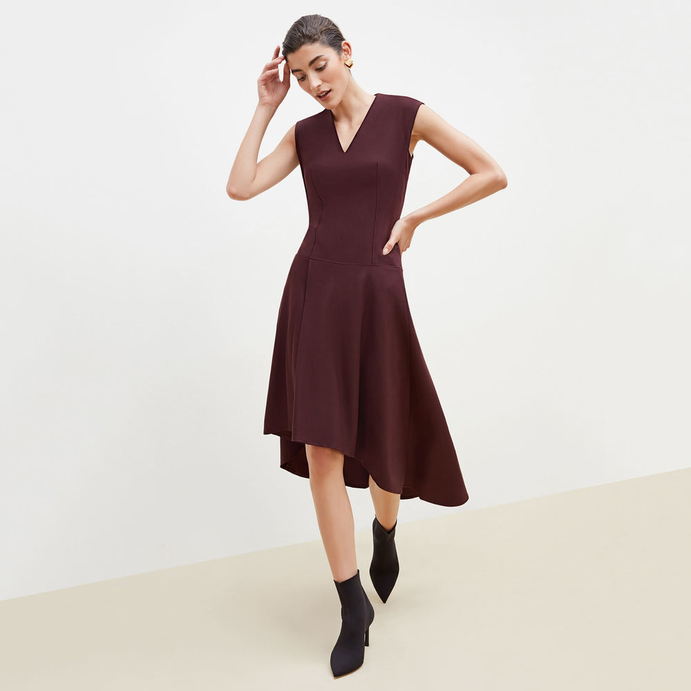 Front image of a woman standing wearing the Kelsey Dress-Sharkskin in garnet