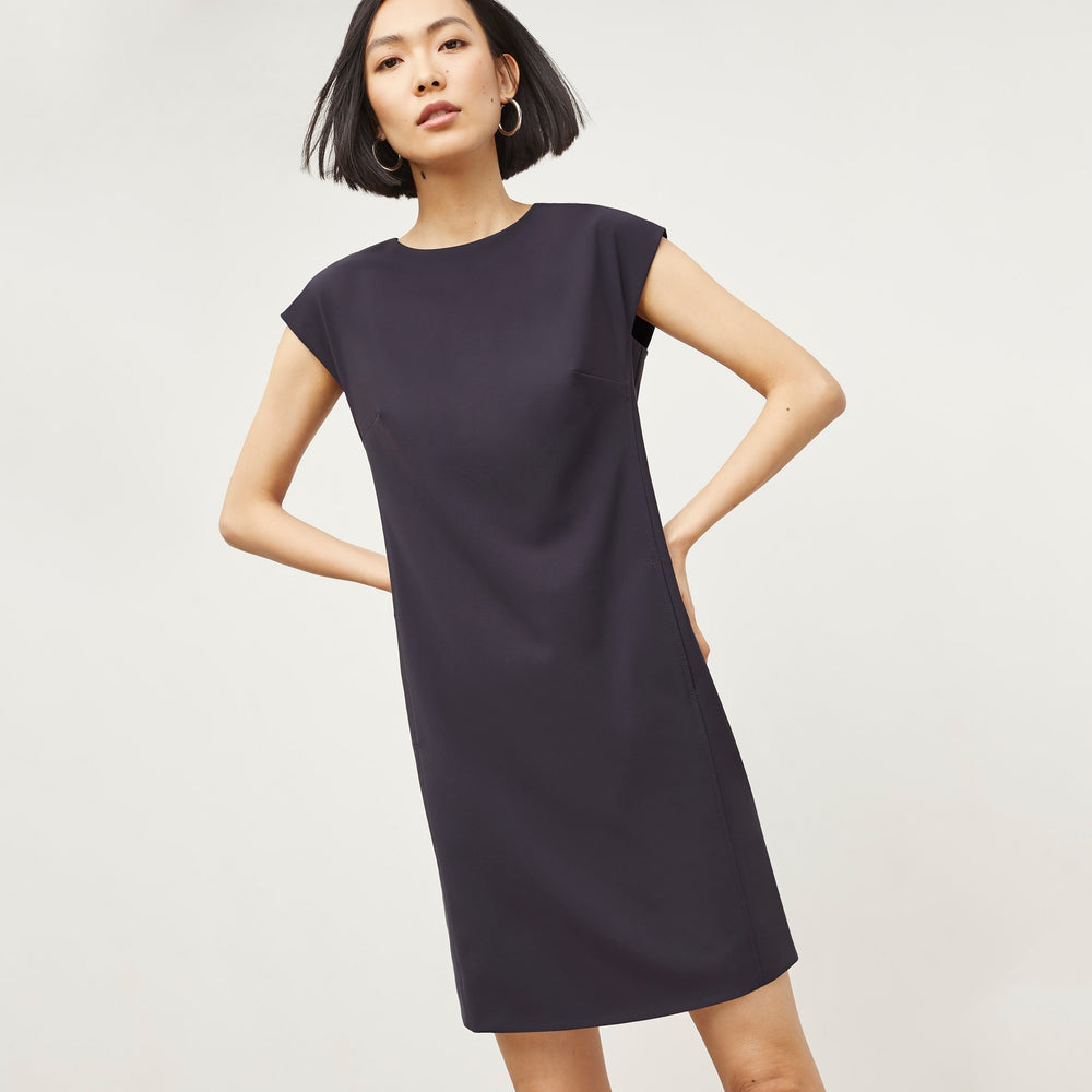 Front image of a woman standing wearing the Maaza Dress—Origami Suiting in Cool Charcoal