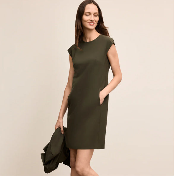 Woman wearing a green dress against a beige background