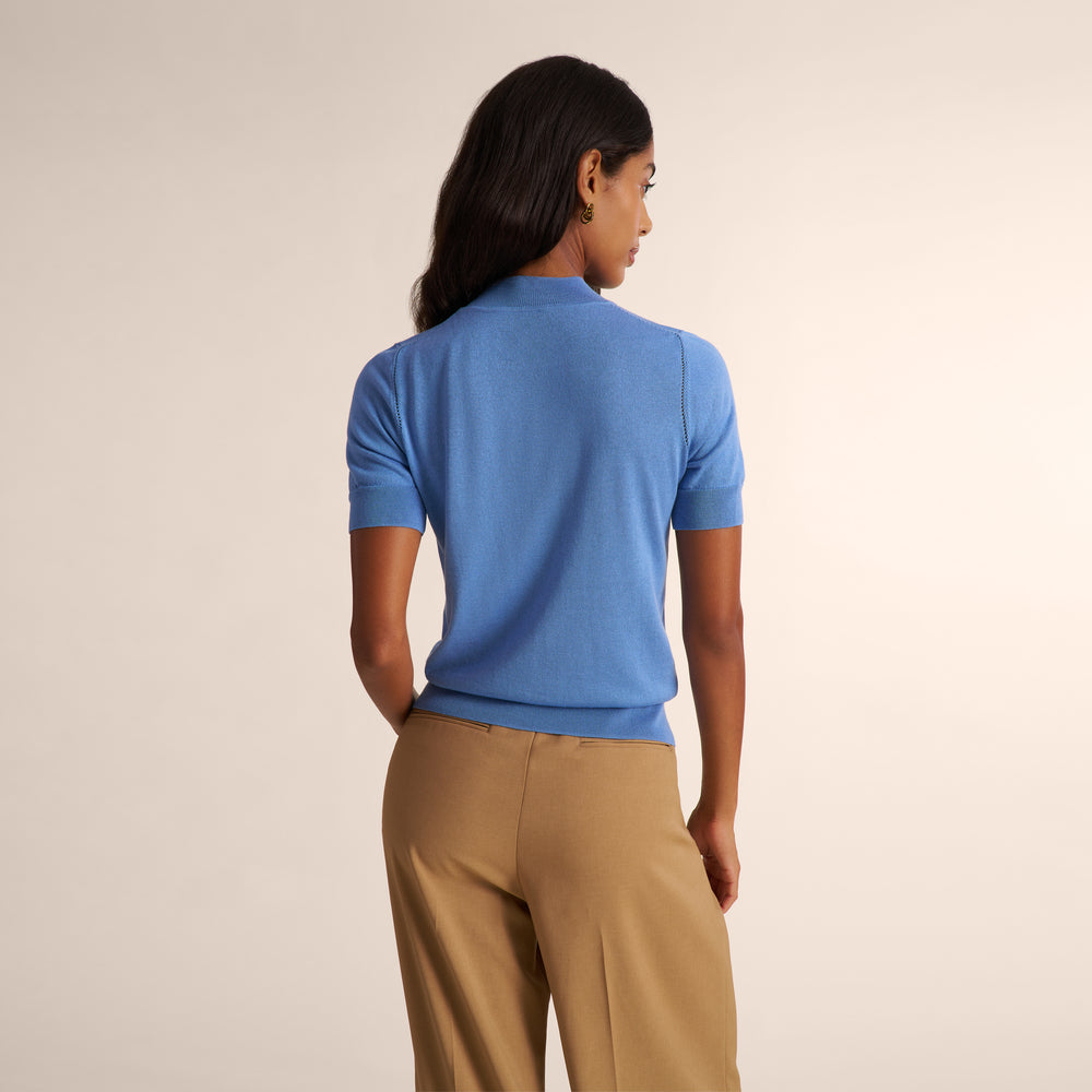 Woman wearing a blue splendor color short sleeve sweater with beige wide leg pants