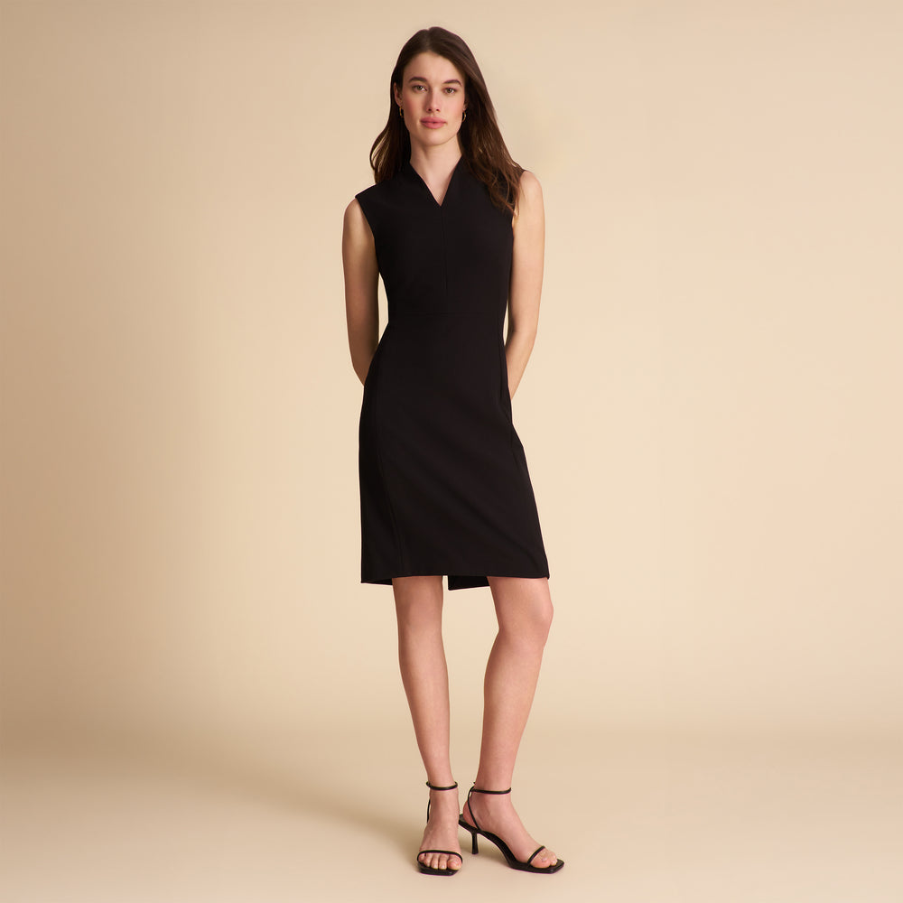 Woman wearing a black sleeveless dress on a beige background