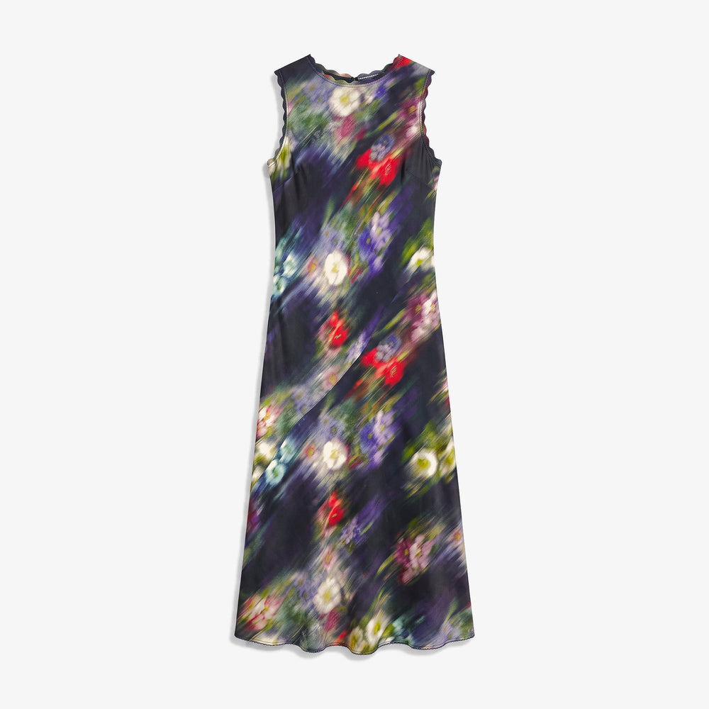 A sleeveless midi dress with a dark abstract floral print featuring purple, red, green, and yellow bokeh-like circles on a black background, shown against a light gray studio backdrop.