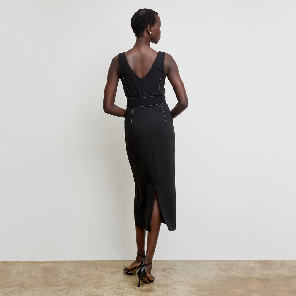 back image of a woman wearing the carmela dress in black with topstitch