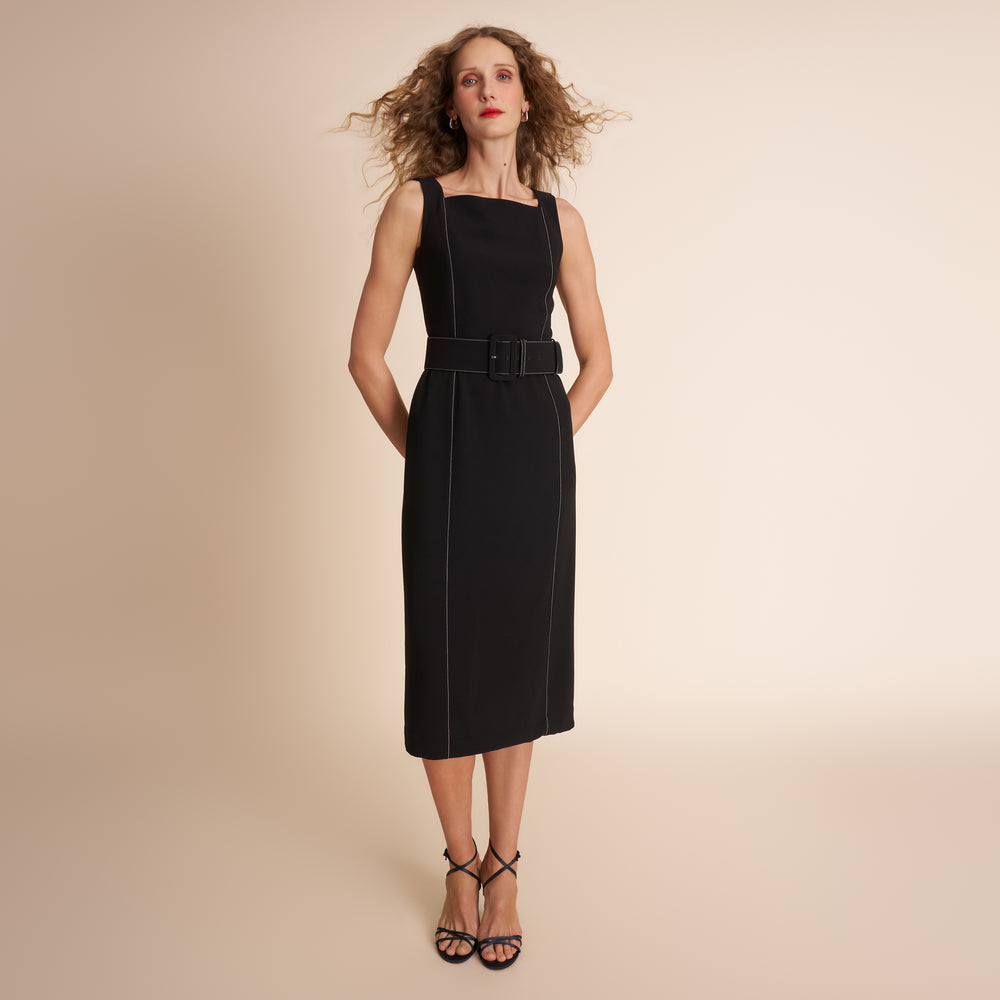 Woman wearing a black dress against a beige background