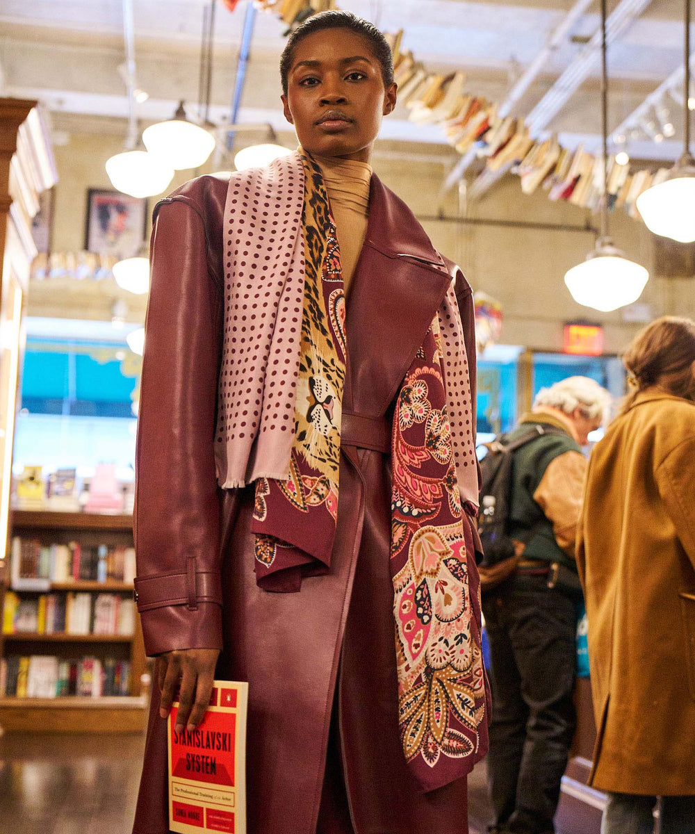 Person wearing a patterned coat in a bookstore setting