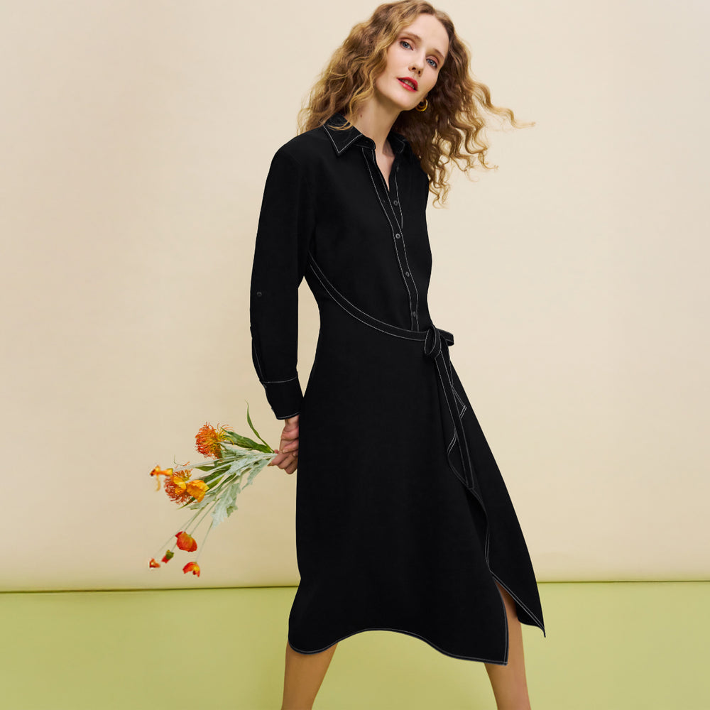Woman wearing a black dress holding flowers against a beige background