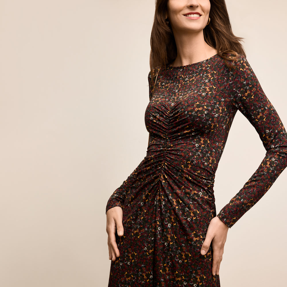 Woman wearing a patterned dress against a beige background