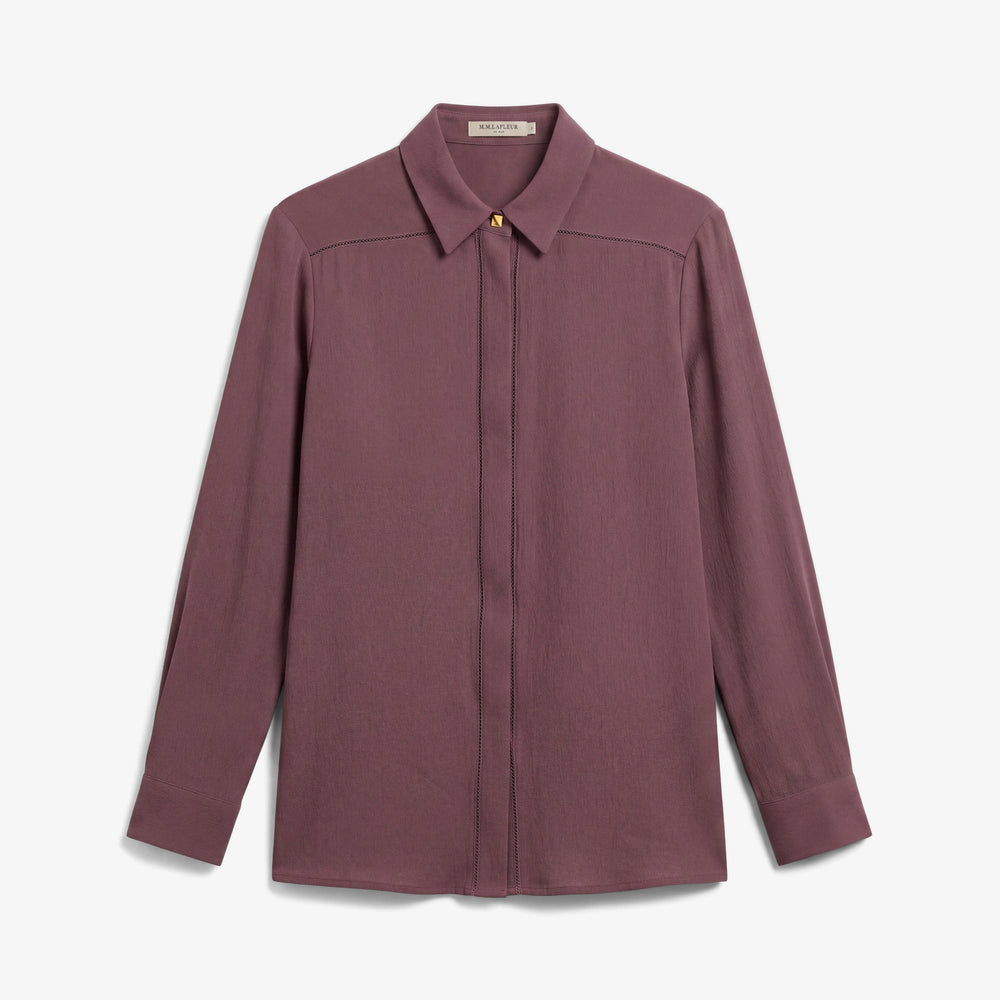 A long-sleeve button-up shirt in a dusty rose or mauve color, featuring a pointed collar, a single visible gold button at the collar, and a subtle horizontal seam across the chest, presented on a clean white background.