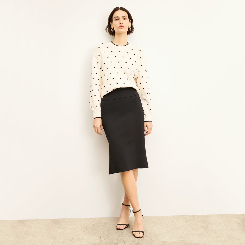 Front image of a woman standing wearing the harlem skirt in black