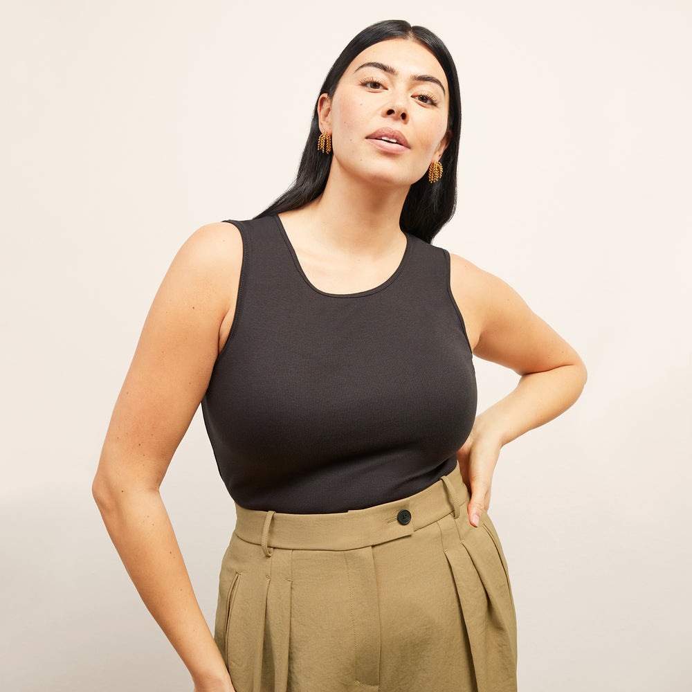 Front image of a woman standing wearing the paige top in fine ribbed cotton in black