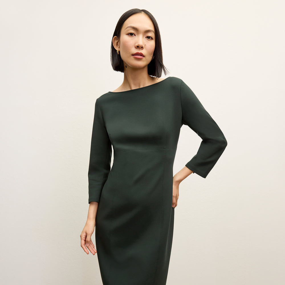 front image of a woman wearing the winston dress in dark emerald