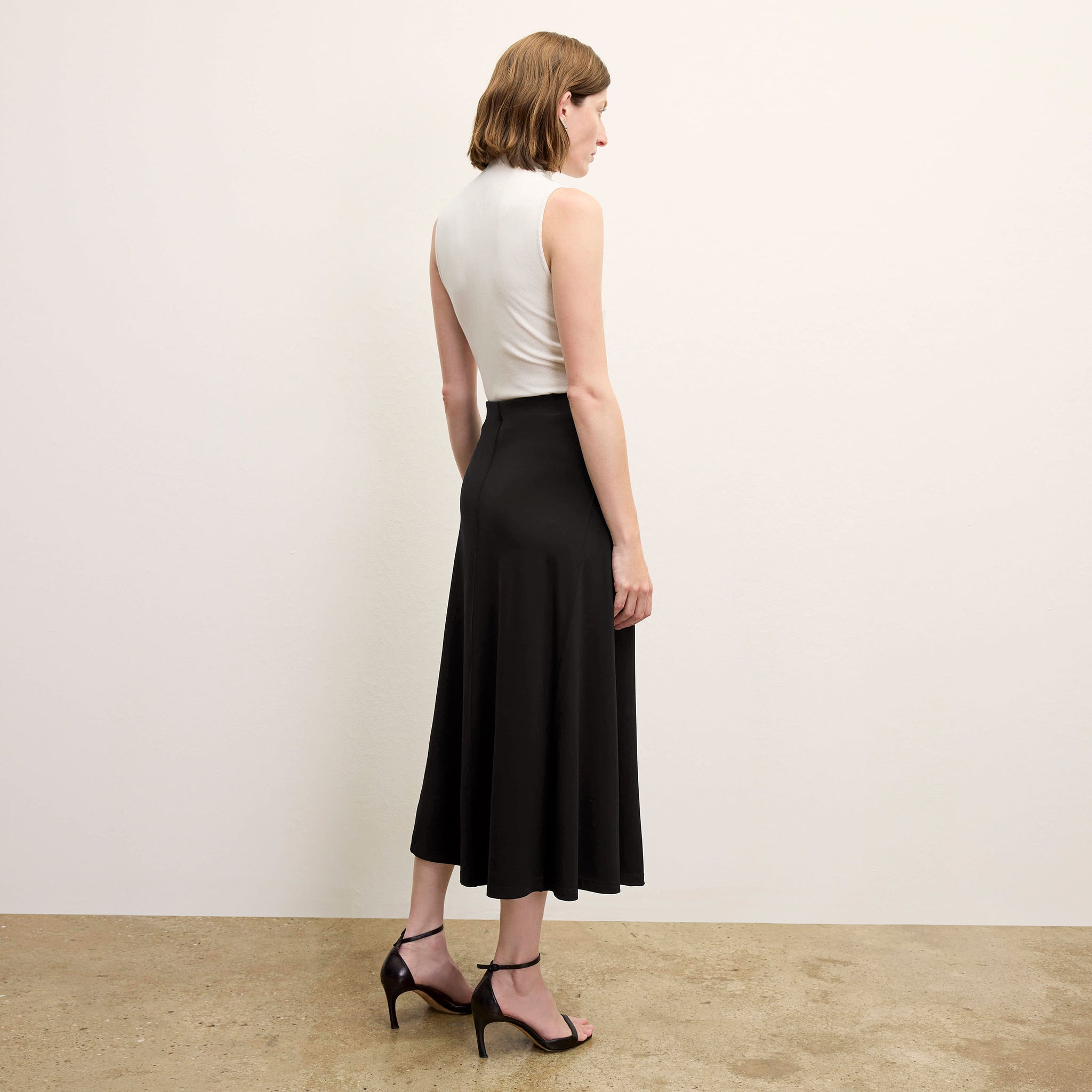 back image of a woman wearing the misty skirt in black 