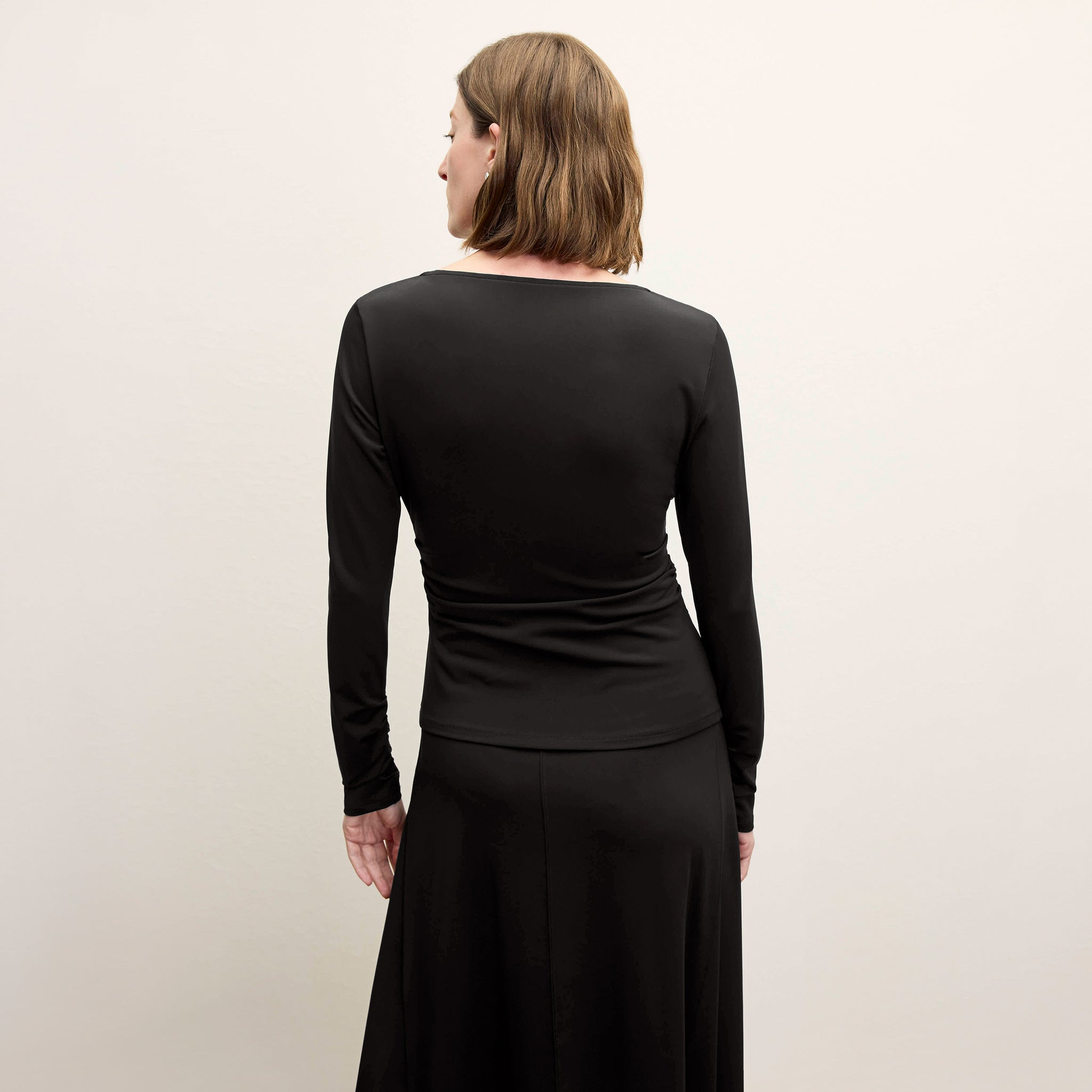 back image of a woman wearing the misty skirt in black 