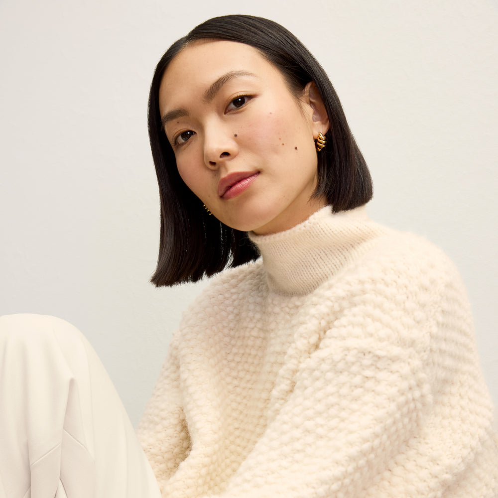 front image of a woman wearing the lea sweater in snow