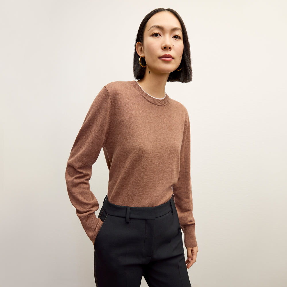 front image of a woman wearing the kit sweater in camel/ivory
