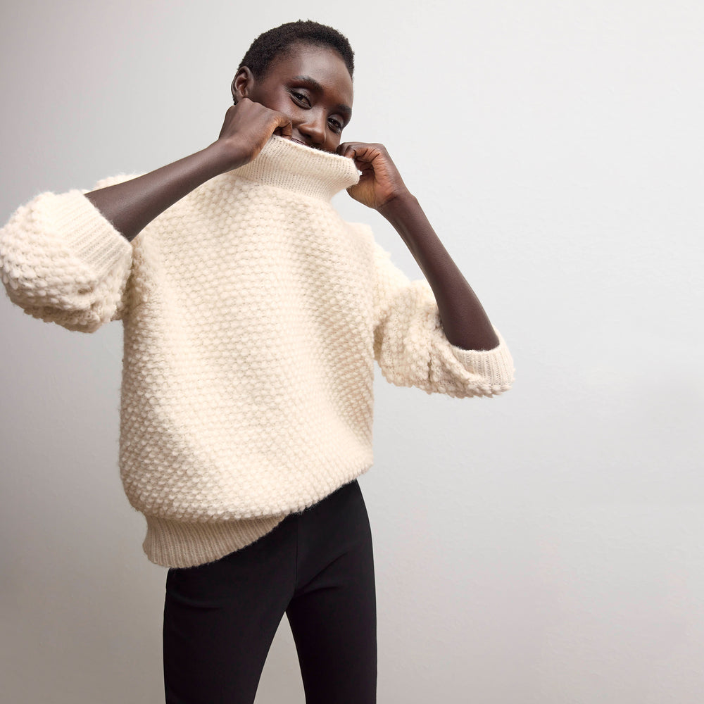 front image of a woman wearing the lea sweater in snow