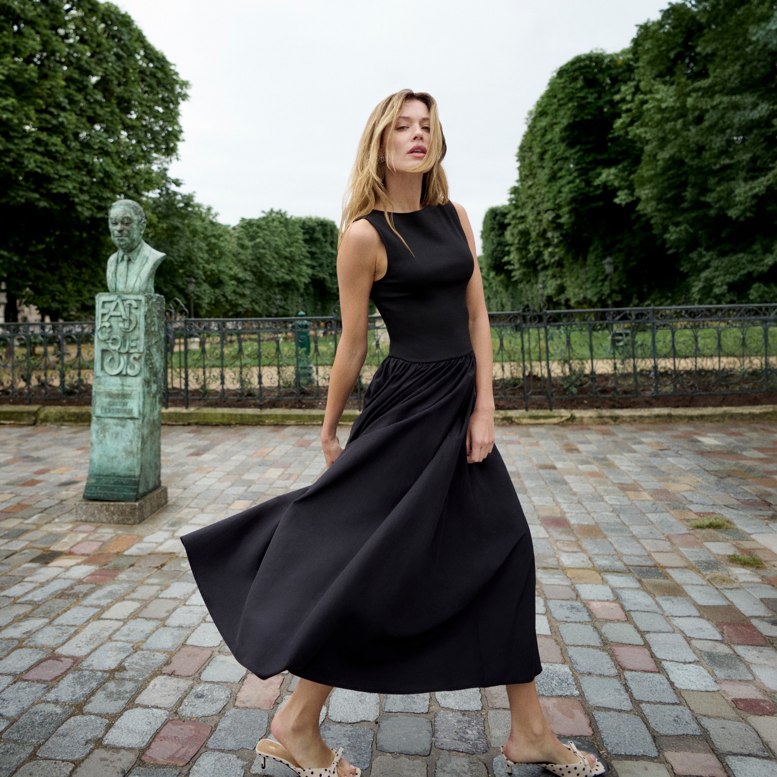 Woman wearing a sleeveless black maxi dress | Lead