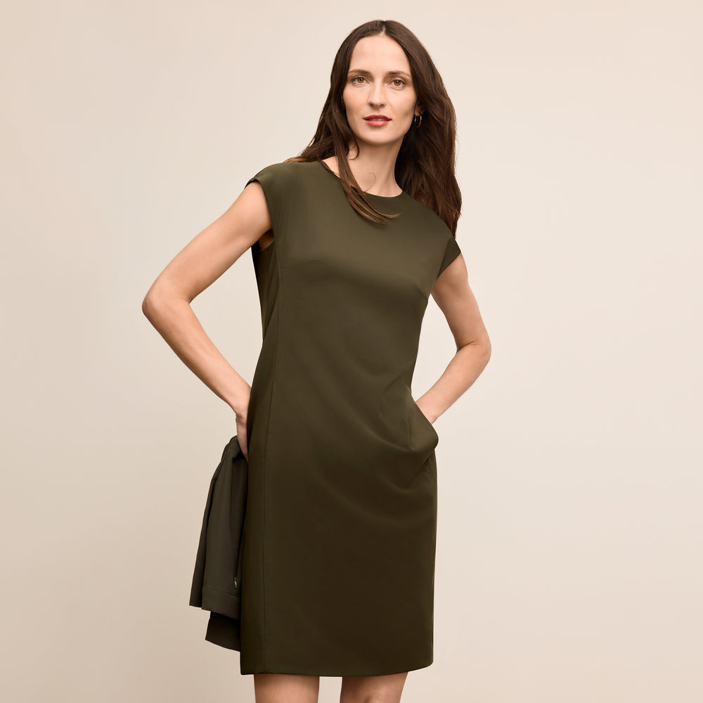 Woman wearing a green dress against a beige background