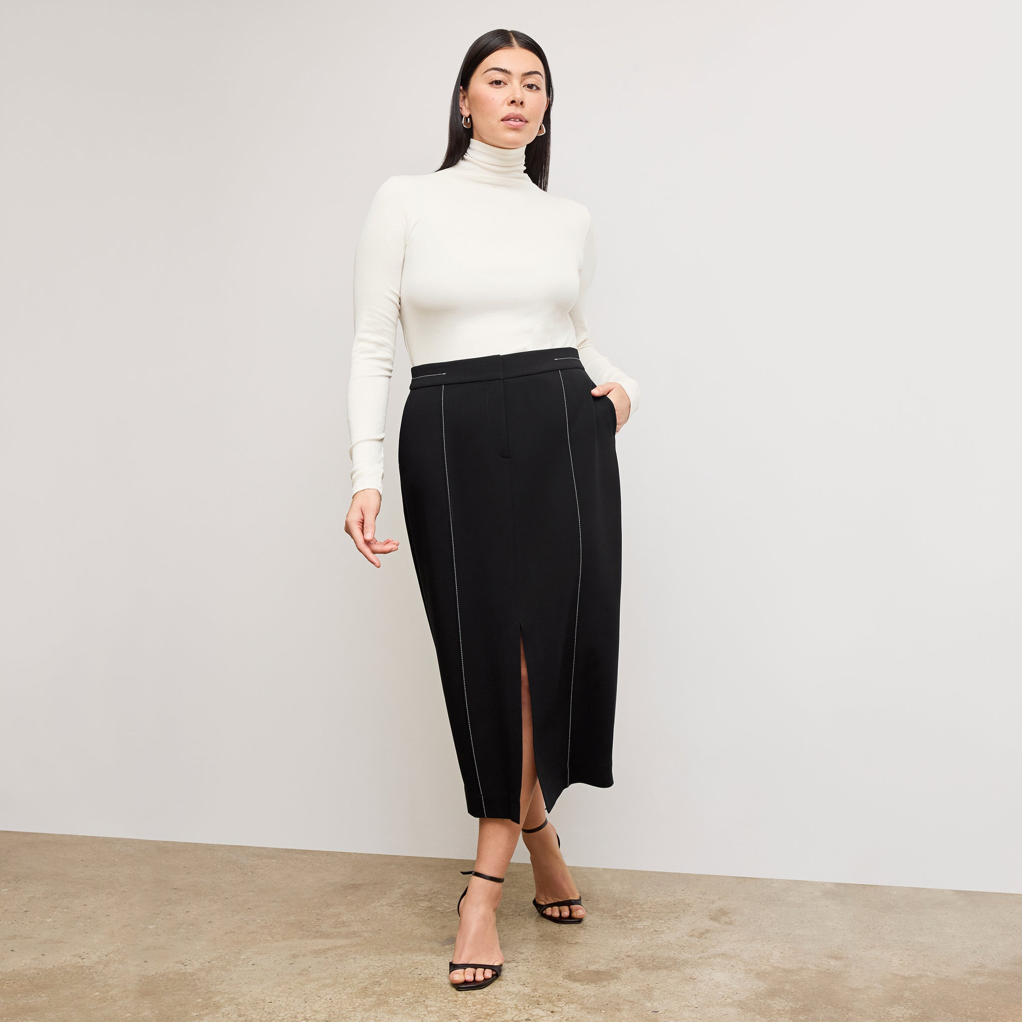 front image of a woman wearing the meghan skirt in black with topstitch