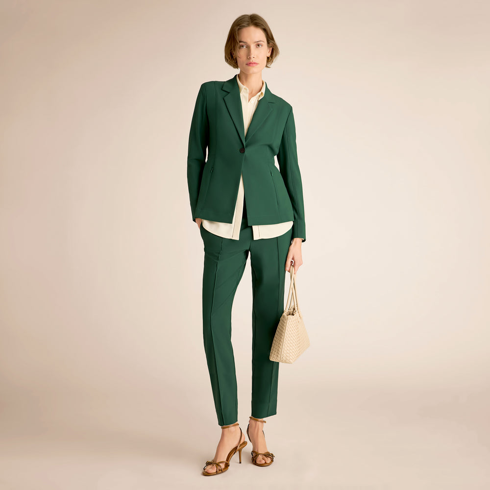 Woman wearing a green suit with a beige background