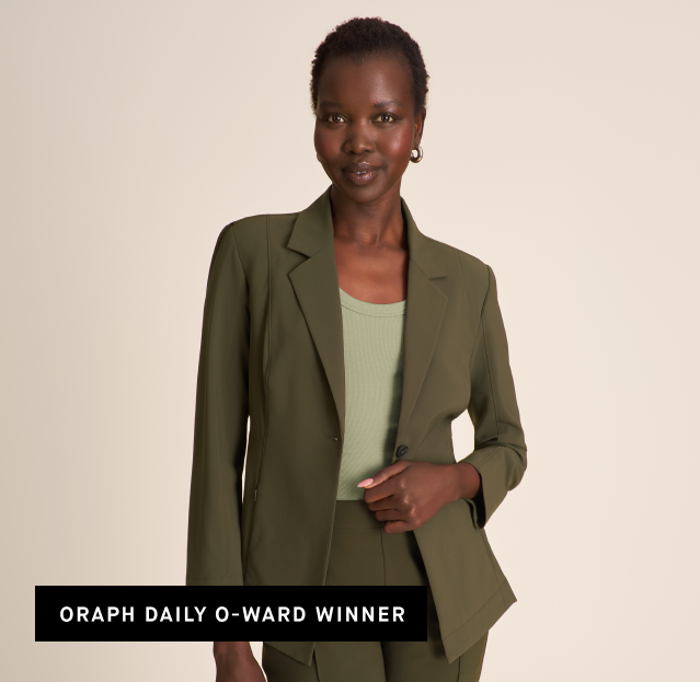 A woman modeling an olive green tailored blazer and matching trousers over a light sage green ribbed top, against a plain beige studio background. A black text banner at the bottom reads 'ORAPH DAILY O-WARD WINNER'.