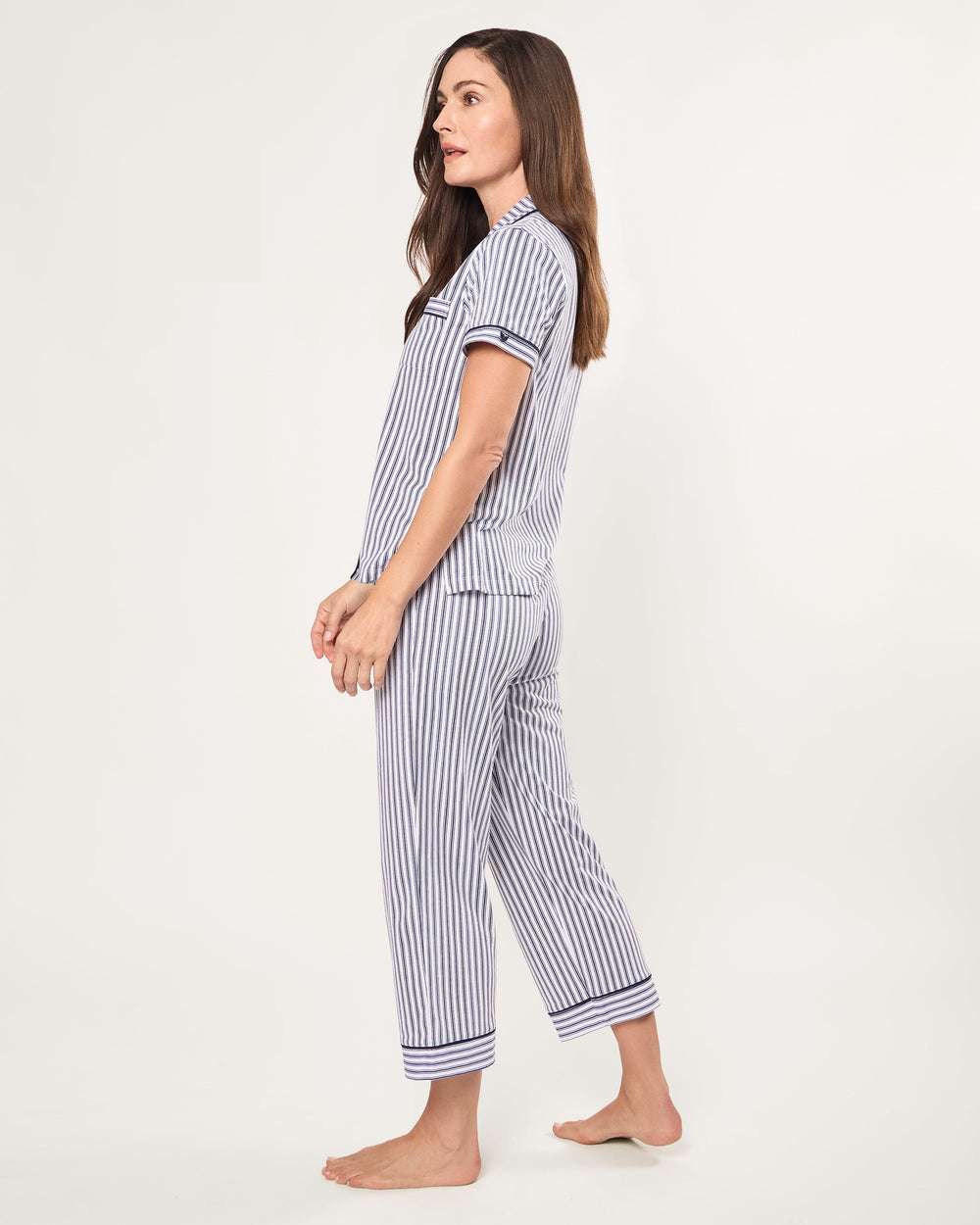 Woman wearing a blue and white striped pajama set on a white background
