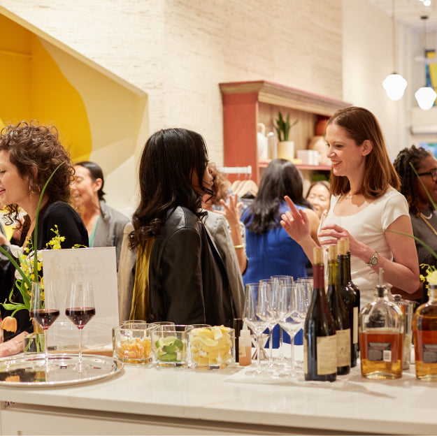 People at a social event with wine and snacks on a table